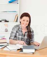 Young beautiful red-haired girl relaxing with a laptop