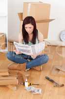 Beautiful red-haired girl reading a manual before do-it-yourself