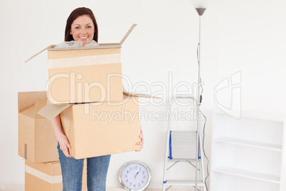 Attractive red-haired woman holding some carboard boxes