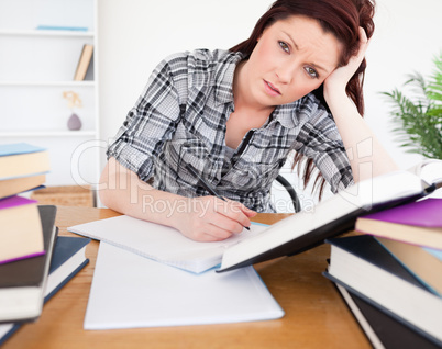 Good looking depressed female studying at her desk