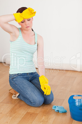 Attractive red-haired woman having a break while cleaning the fl