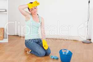 Pretty red-haired woman having a break while cleaning the floor