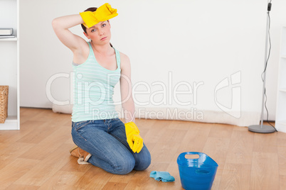 Cute red-haired woman having a break while cleaning the floor
