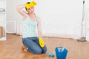 Cute red-haired woman having a break while cleaning the floor