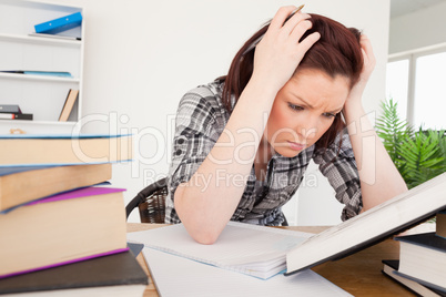 Attractive depresed female studying at her desk