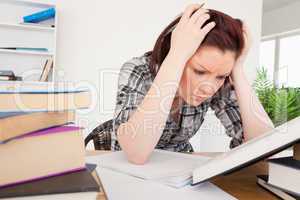 Attractive depresed female studying at her desk