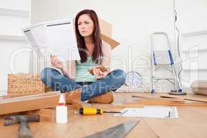 Lovely red-haired female reading a manual before do-it-yourself