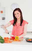 Gorgeous red-haired woman cutting some carrots in the kitchen