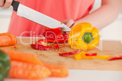 Young woman cutting some vegetables in the kitchen