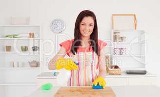 Gorgeous red-haired woman cleaning a cutting board in the kitche