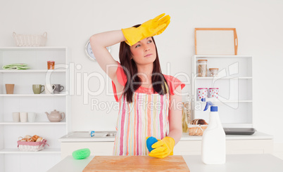 Pretty red-haired woman posing while cleaning a cutting board in