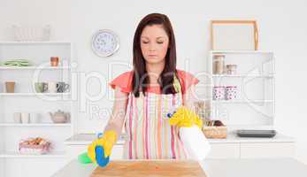 Gorgeous red-haired woman cleaning carefully a cutting board in