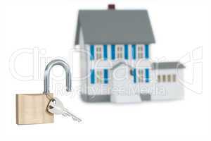 Miniature house and opened padlock
