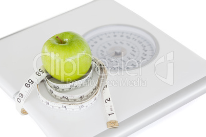 Green apple circled with a tape measure and weigh-scale