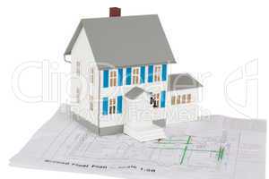 Gray toy house model on a ground floor plan