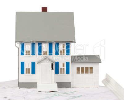 Front view of a toy house model on a ground floor plan