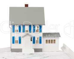 Front view of a toy house model on a ground floor plan