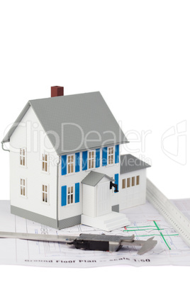 Toy house model and caliper on a ground floor plan
