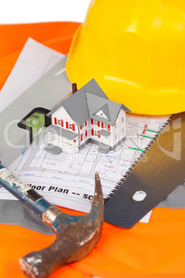 Tools and miniature house on an orange jacket