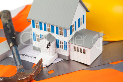 Tools and miniature house on an orange jacket