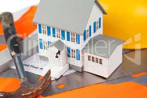 Tools and miniature house on an orange jacket