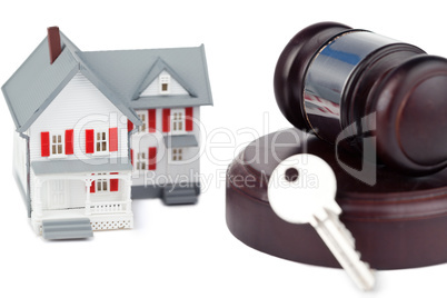 Closeup of a toy house model and a brown gavel