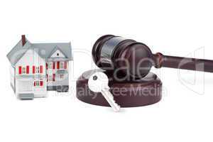 Closeup of a toy house model and a brown gavel