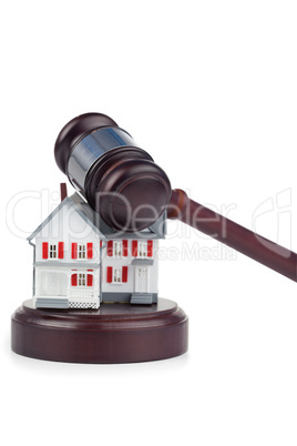 Closeup of a toy house model and a brown gavel