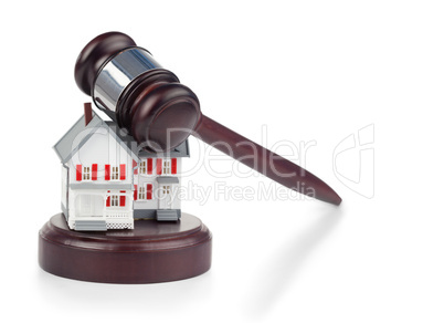 Closeup of a toy house model and a brown gavel