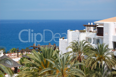 View on the beach, palms and building of luxury hotel, Tenerife