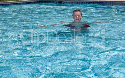 Senior retired man swimming in pool