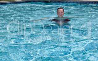 Senior retired man swimming in pool