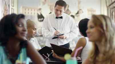 People ordering meal to waiter in restaurant