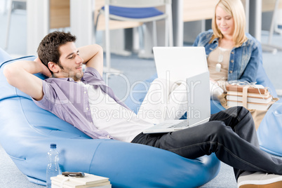 Young students at high-school relaxing with laptop