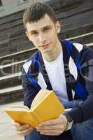 Male student on campus with textbooks