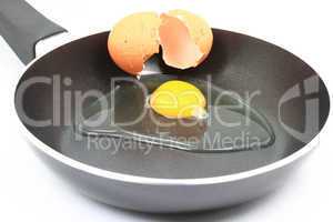 Cracking organic raw egg to be fried for breakfast