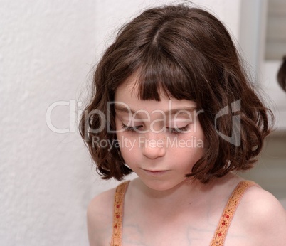 Serious cute little girl looking down