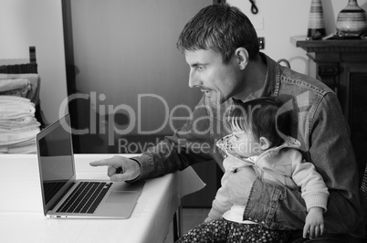 Man Teaching his Daughter Using Laptop