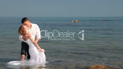 bride and groom kissing near the sea