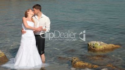 bride and groom kissing near the sea