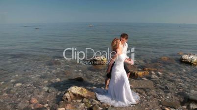bride and groom kissing near the sea