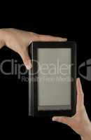 Hand holding an electronic book reader on the black background