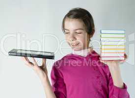 Teen girl holds electronic book in one hand and a stack of books in other