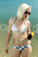 Junge Frau im Urlaub am Strand geniest ihren Coktail 650
