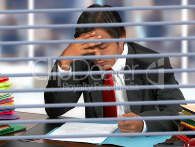 Businessman Reading Documents At His Desk