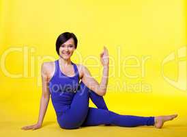 woman sit in yoga pose - padmasana on yellow