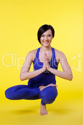 woman smile in yoga pose - blue on yellow