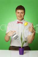 Close-up of a young man watering a flower