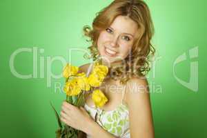 Attractive girl hugging a bouquet of yellow tulips