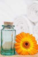 Sunflower with a glass phial and white towels